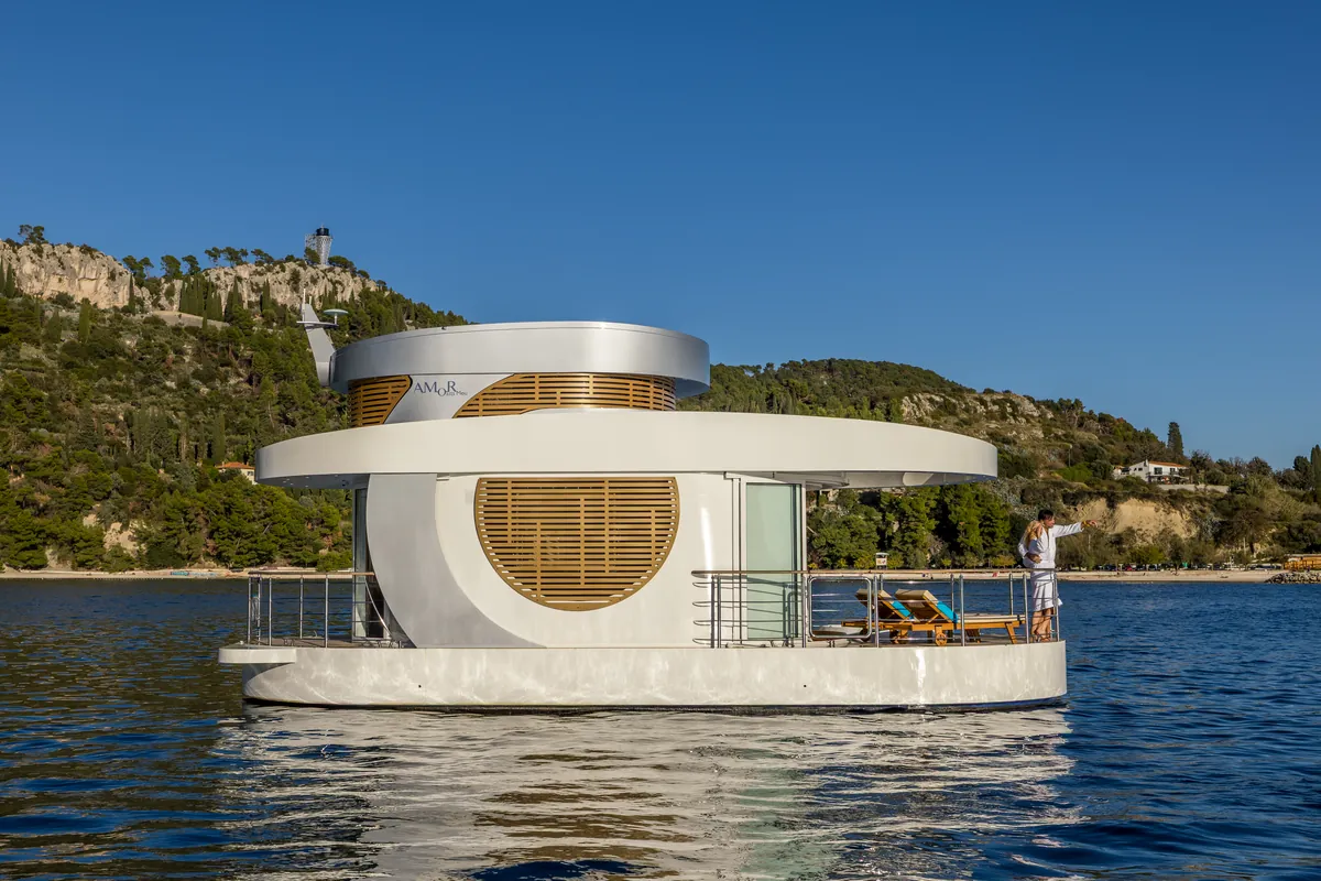 Amor off Split by day, a couple in bathrobes on the front deck and the pine-covered Marjan hill behind